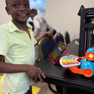 Boy smiling at Roboclub with tablet and robot