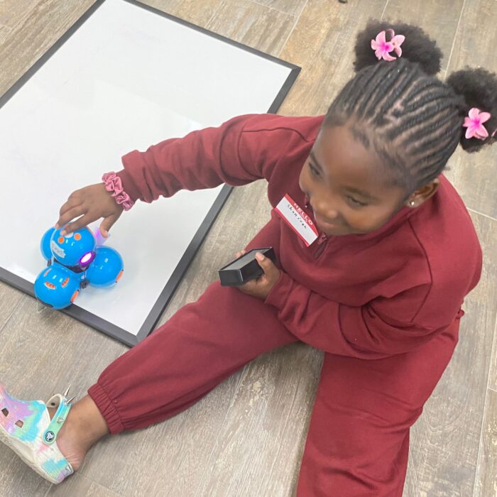 Young girl plays with robot in Roboclub